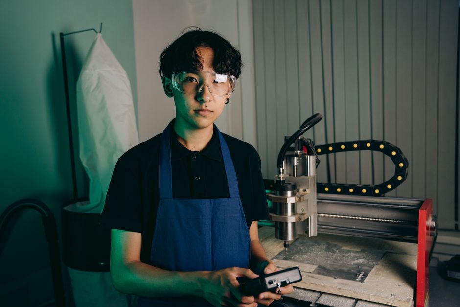 産業用ワークショップでCNCマシンを操作する若いエンジニア。