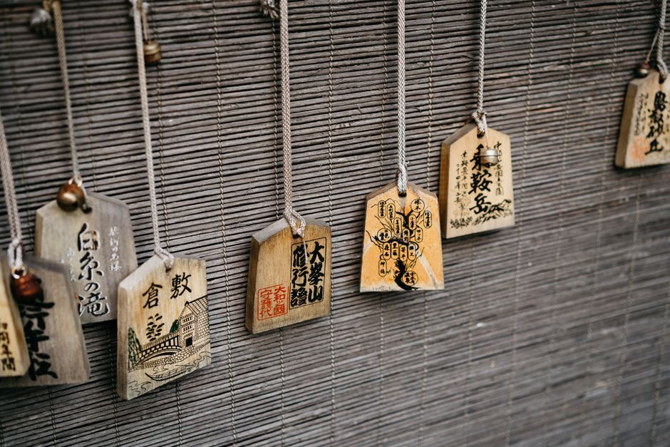 神社の竹マットの上に掛けられた伝統的な日本の絵馬のクローズアップ。