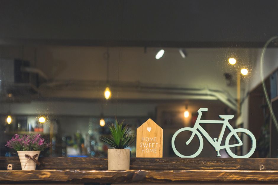 植物、木製の自転車、'Home Sweet Home' の装飾が特徴の温かい室内シーン。