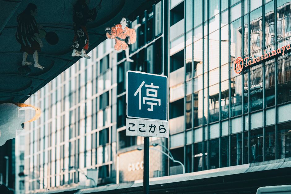 賑やかな都市環境の中にある、近代建築を反映した日本の道路標識。