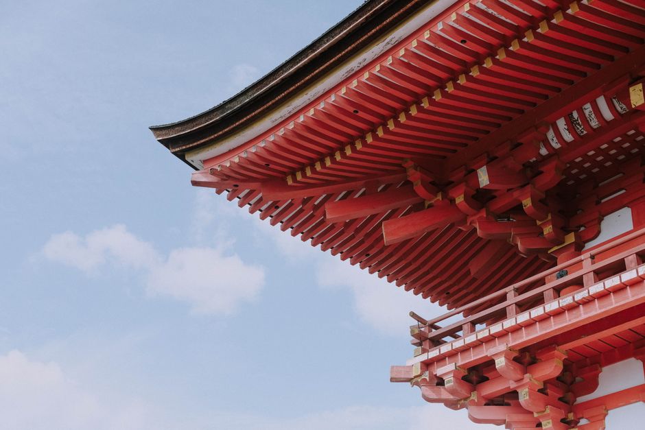日本の京都で青空を背景にした赤い日本の寺院の屋根のクローズアップ。