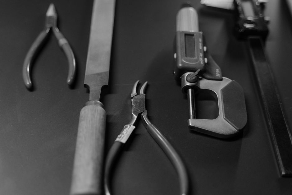 様々な作業工具がきれいに配置されたモノクロ画像。