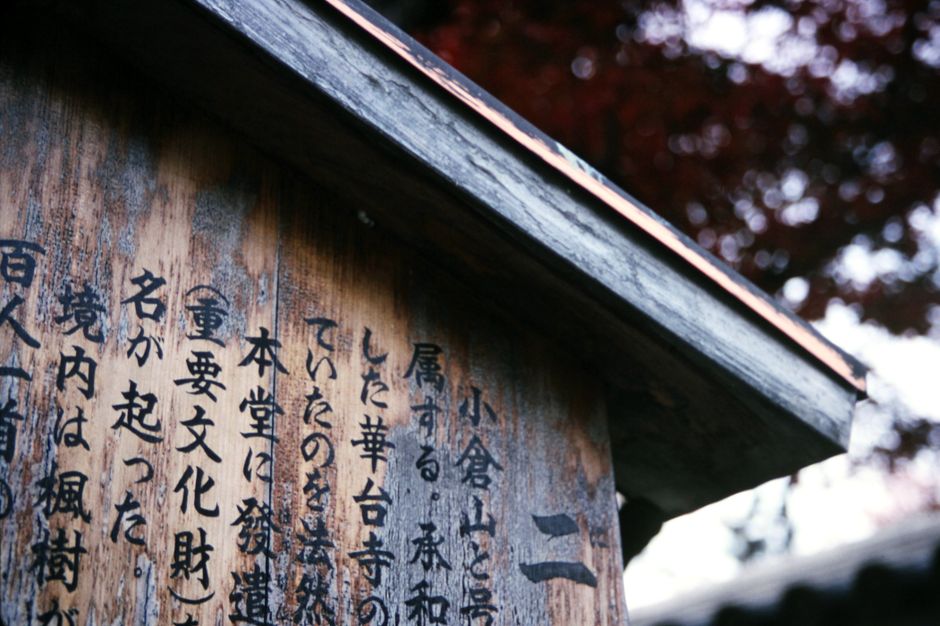 風化した木製看板のクローズアップ。日本の漢字が特徴的で文化的な深みを加えています。