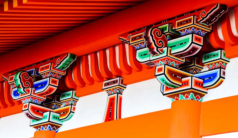 伝統的なデザイン要素と色彩を展示する日本の寺院の活気に満ちた詳細な建築.