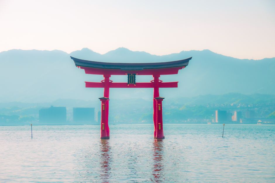 伝統と静かな水、山々が融合した、厳島神社のアイコニックな鳥居の魅力的なショット。